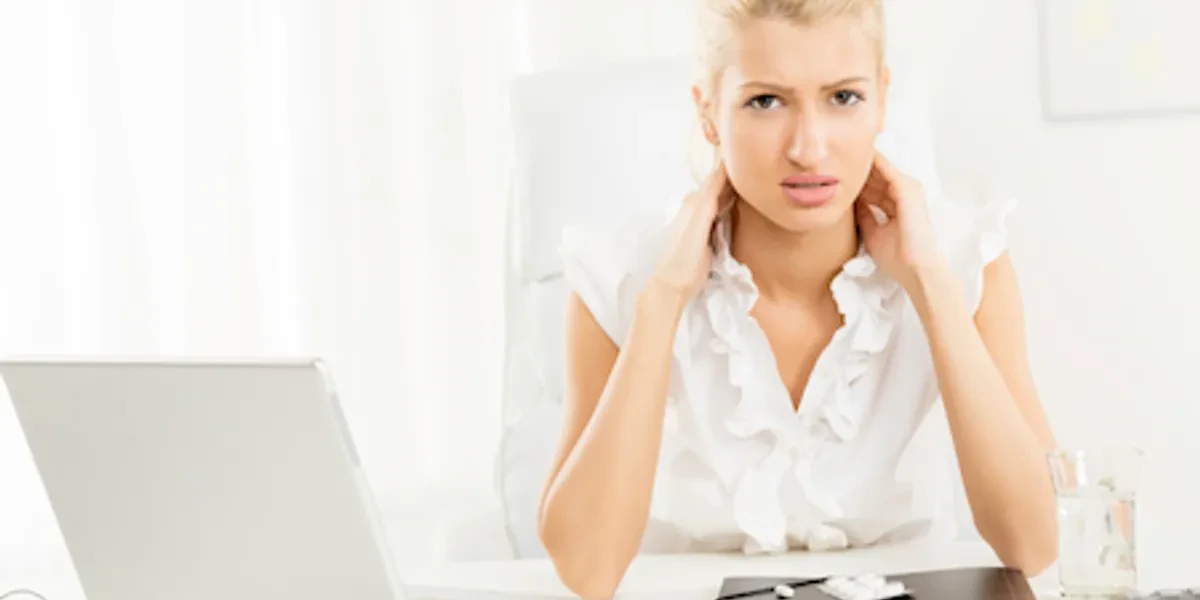 Woman at desk with neck pain — desk stretch guide